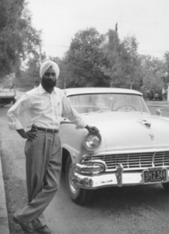 Jarnail Singh Purewal posing in front of his new car, Yuba City 1955